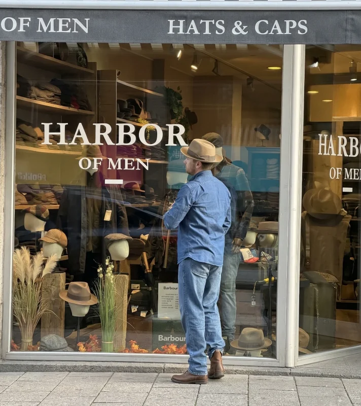 Voorkant van de hoedenwinkel Harbor of Men, met een man die in de etalage kijkt