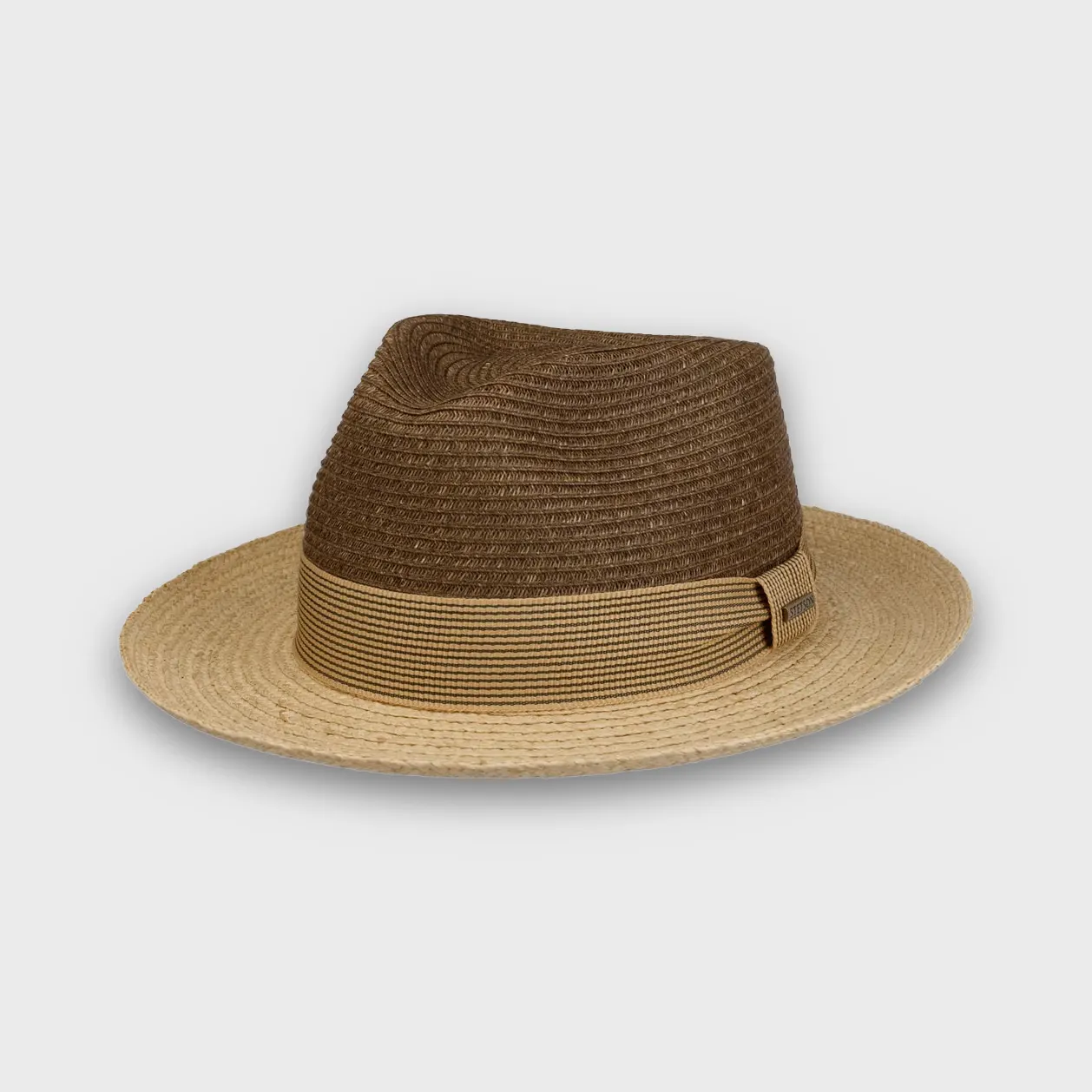 Twee kleurige zomer hoed, waarvan de kroon bruin is en de hoedrand zandkleurig, gemaakt van raffia en viscose.