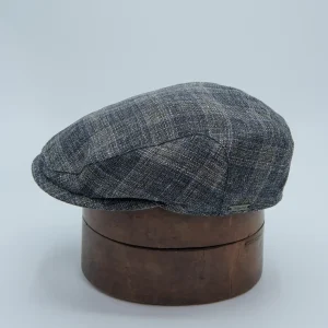 Casquette plate grise en lin, laine et coton à carreaux. Portée par un homme.