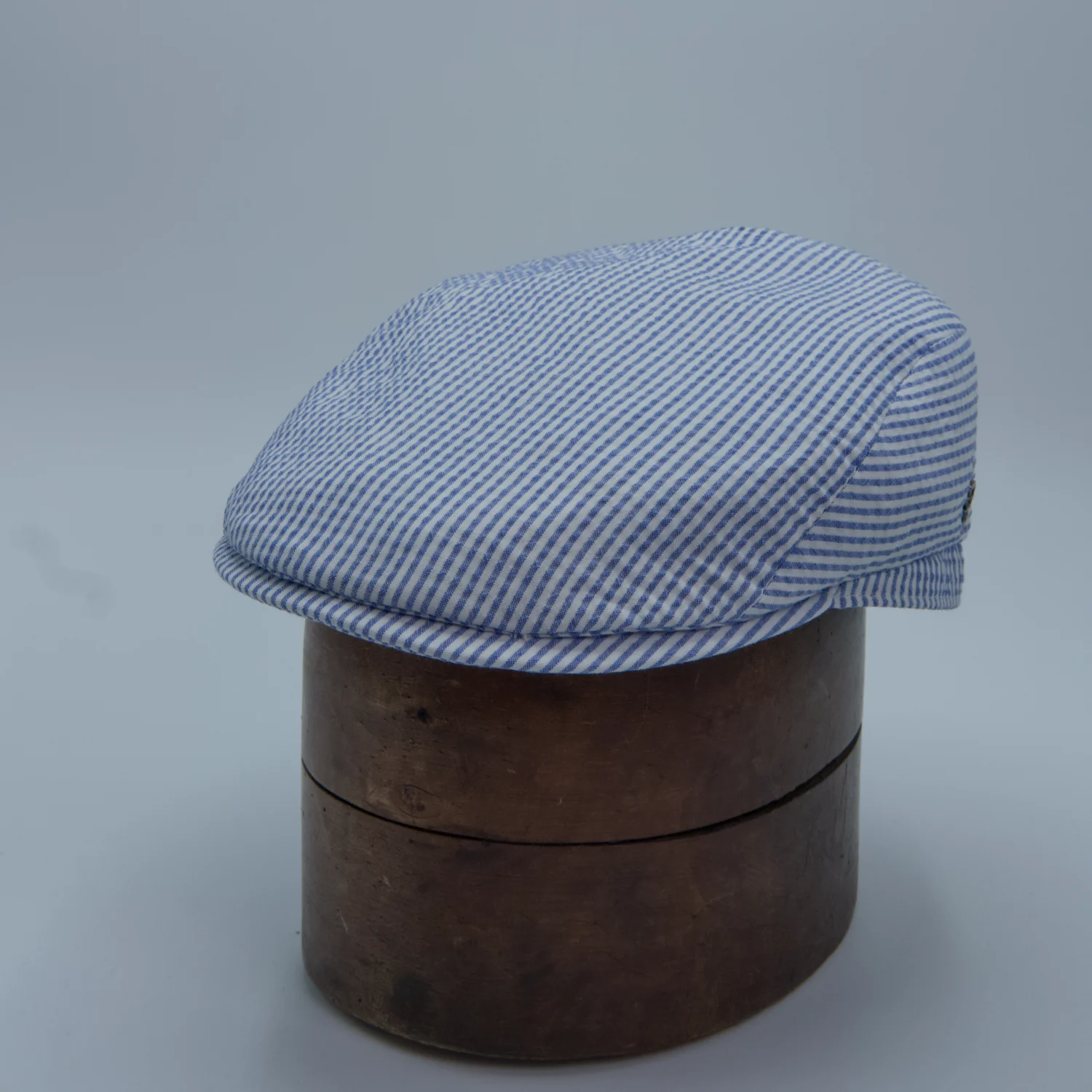 Flat cap with a blue stripe pattern in seersucker, by City Sport, side.