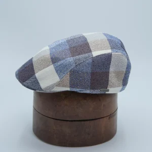 Casquette plate en mélange lin et laine multicolore à carrés gris, bleus et bruns, présentée sur une tête de présentation.