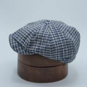 Casquette newspaper boy à carreaux blancs et bleus sur une forme à chapeau, de la marque Wigéns.