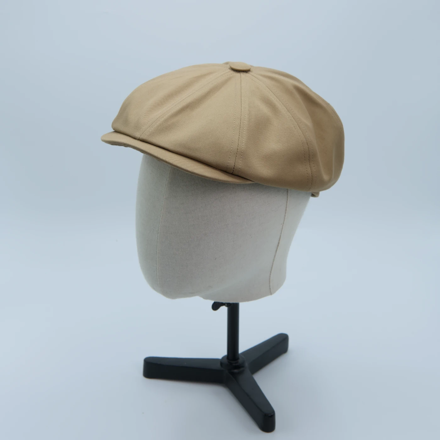 Casquette newspaper boy camel brun clair, en matière imperméable, présentée sur une tête de mannequin
