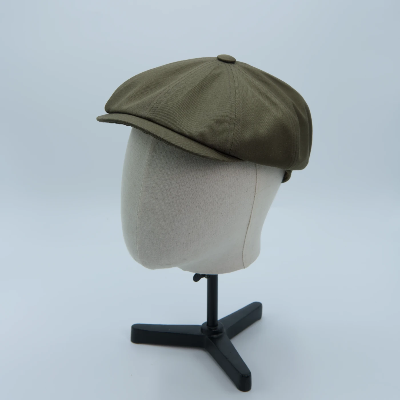 Casquette newspaper boy vert mousse, en tissu imperméable, présentée sur une tête de mannequin