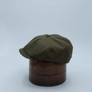 Casquette newspaper boy vert mousse, en tissu imperméable, posée sur une tête de présentation
