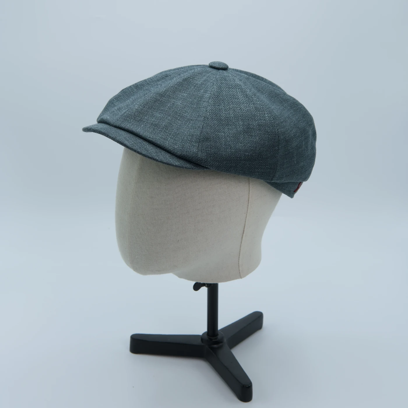 Ash green newspaper boy cap, made from premium Zegna cloth, shown on a mannequin head