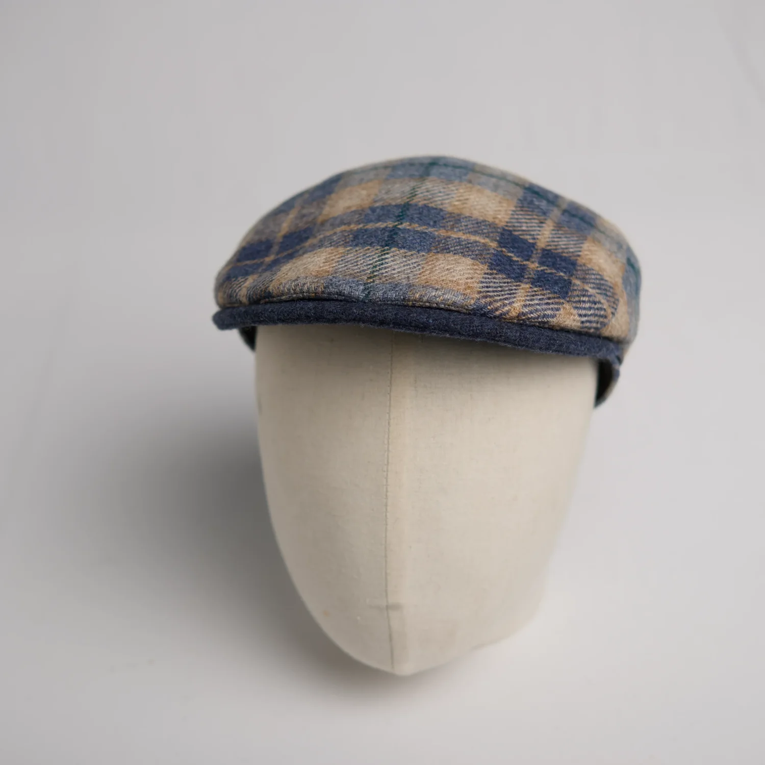 Flatcap modern City Sport, une variante moderne de la flat cap classique, à carreaux bleu et caramel avec visière bleue, vue de côté