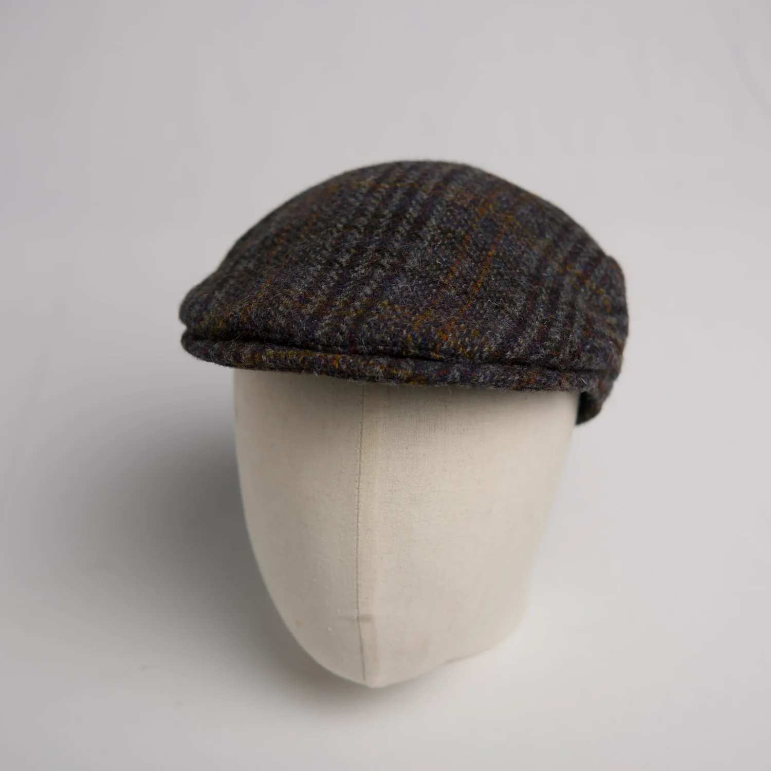Flatcap moderne City Sport bleu marine à carreaux noirs et autres couleurs subtiles, vue de côté.