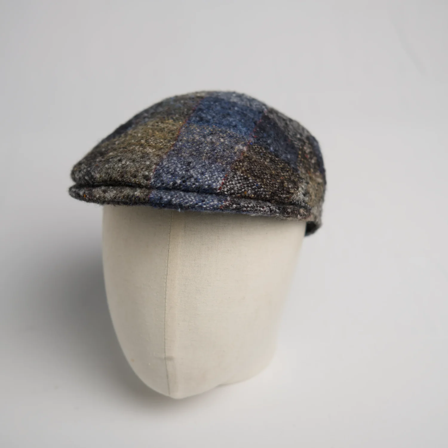 Flatcap City Sport de forme moderne à motif à carreaux, en laine vierge aux tons bleus rustiques, vue de côté.